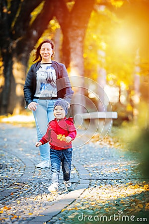 2 years old toddler have fun outdoor in autumn yellow park Stock Photo