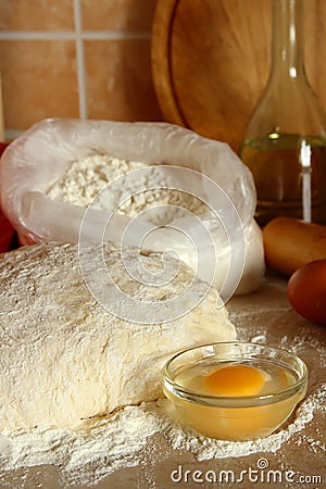 Yeast dough, eggs, and flour on the table. Stock Photo