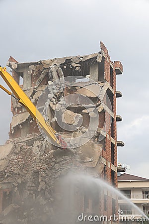 Yellow arrow of a crane and a stream of water on the dismantling of an unfinished high building, Turkey, Alanya Stock Photo