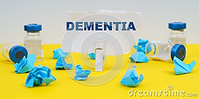 On a yellow background are ampoules, blue crumpled paper and paper with the inscription - DEMENTIA Stock Photo