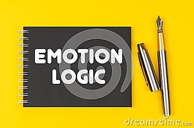 On a yellow background lies a pen and a black notebook with the inscription -Emotion Logic Stock Photo