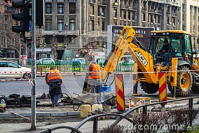 Yellow backhoe loader and workers on construction site ready for working in Bucharest, Romania, 2020 Editorial Stock Photo