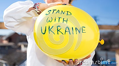 Yellow balloon with the inscription stand with Ukraine in children hands Stock Photo