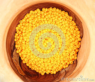 Yellow beads in wooden bowl. Jewelry. Creativeness Stock Photo