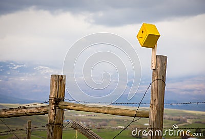 Yellow Birdhouse On A Barbed Wire Fence Stock Photo
