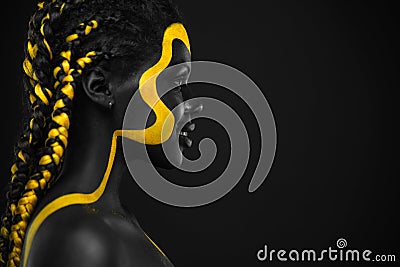 Woman on abstract poster with gold face art. Yellow and black body paint. Young girl with bodypaint. An amazing model Stock Photo