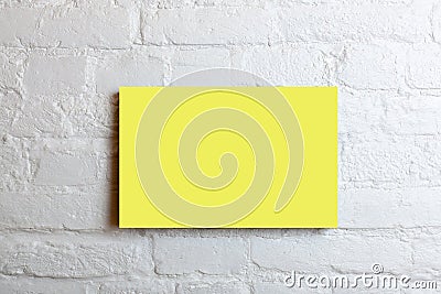 Yellow blank poster in a white brick wall. Template Mock up for your content Stock Photo