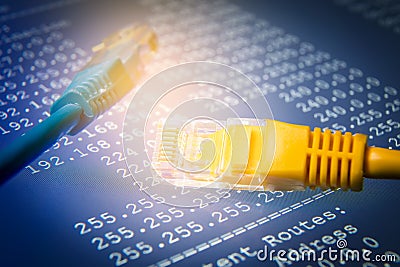 Yellow and blue ethernet cables with routing table, blue background Stock Photo