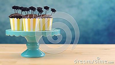 Yellow and blue theme graduation party cupcakes with cap hats toppers. Stock Photo
