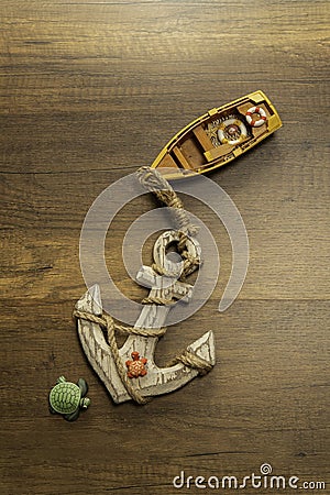Yellow boat with big anchor and turtle on wooden table Stock Photo