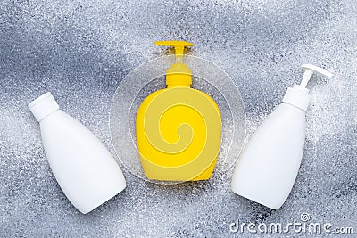 Yellow bottle with detergent, liquid soap. White flacon. Set of plastic bottles with dispenser on a gray background. Pump lotion. Stock Photo