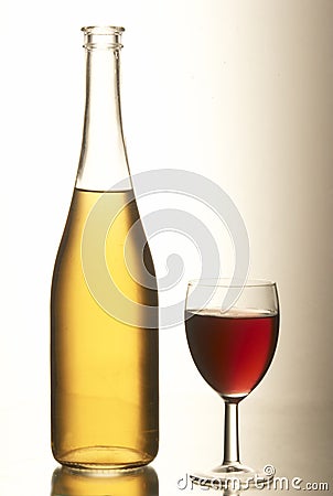 Yellow bottle with a full beaker of red wine. Stock Photo