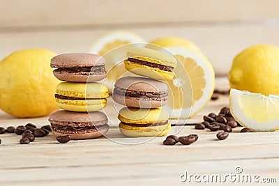 Yellow and brown french macarons with lemons and coffee beans on the wooden board Stock Photo