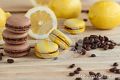 Yellow and brown french macarons with lemons and coffee beans on the wooden board Stock Photo