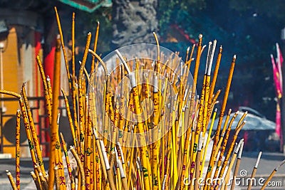 Yellow Buddhist prayer sticks burning in the censer at Po Lin Monastery, Lantau Island, Hong Kong Stock Photo