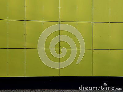 Yellow building is lined with square panels of plastic, fiberglass. fastened with screws. Washable walls is a major advantage. on Stock Photo