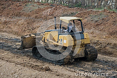 Yellow Bulldozer scooping dirt at a construction site Editorial Stock Photo