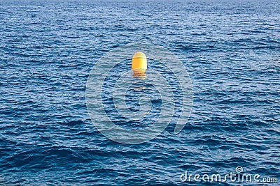 Yellow buoy on background of blue sea, concept loneliness Stock Photo
