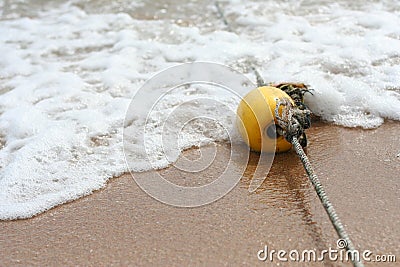 Yellow buoy on the sand beach Stock Photo