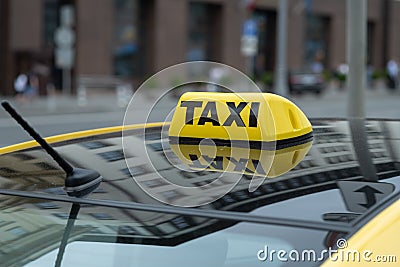 Yellow cab with taxi sign on the roof parked on the city street waiting for passengers to pick up.The taxi is parked on the street Stock Photo