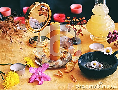 Yellow candle on Litha midsummer Sabbat Solstice celebration witch altar filled with flowers, rose petals, dandelions, crystals Stock Photo