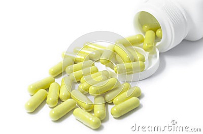 Yellow capsule pills supplement spilled isolated Stock Photo
