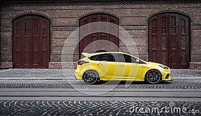 yellow Ford Focus in front of garage doors Editorial Stock Photo