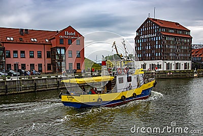 Yellow cargo barge sails along the canal in the Baltic Sea Editorial Stock Photo