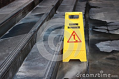 Yellow caution cleaning progress sign on the floor outdoors Stock Photo