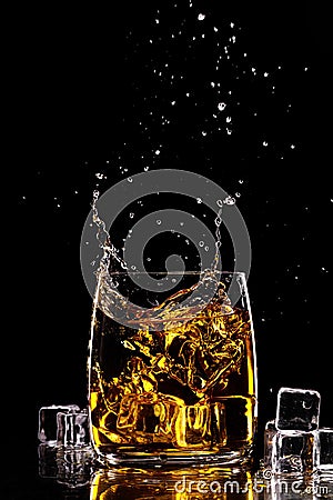 Yellow celebration background liquor reflection cold rocks cocktail rum black splash brandy drink gold scotch ice alcohol whiskey Stock Photo