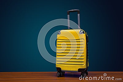 Yellow color traveling suitcase on dark background with copy space Stock Photo