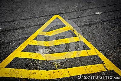 Yellow triangle no parking lines painted on black asphalt road with tyre tracks Stock Photo