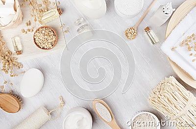 Yellow cosmetics oil, oatmeal flackes and white cream, bath natural accessories on beige wooden background, copy space, top view. Stock Photo