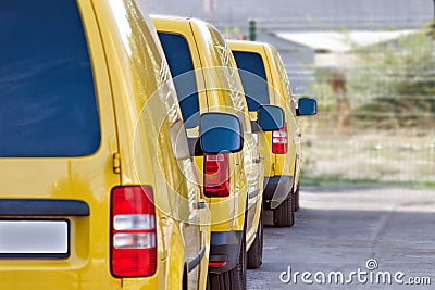 Yellow courier or taxi cars are lined up in parking lot. Stock Photo