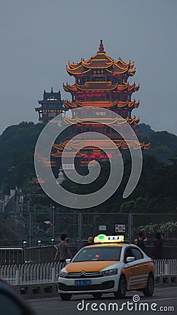 Yellow Crane Tower and a taxi on the Yangtze River bridge in Wuhan at nightfall. Editorial Stock Photo