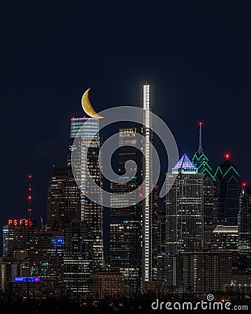 Yellow crescent moon over illuminated Philadelphia skyline at night Editorial Stock Photo