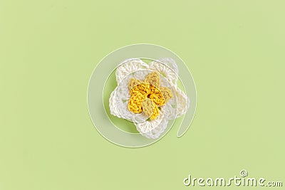 Yellow crocheted flower on a green background Stock Photo