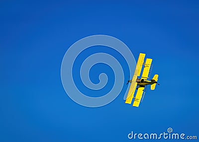 Yellow Crop Duster against a blue sky Stock Photo