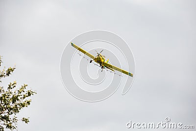 A yellow crop duster in the sky Stock Photo