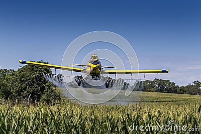 Yellow Crop Duster Spraying Pestisides On Crops Stock Photo