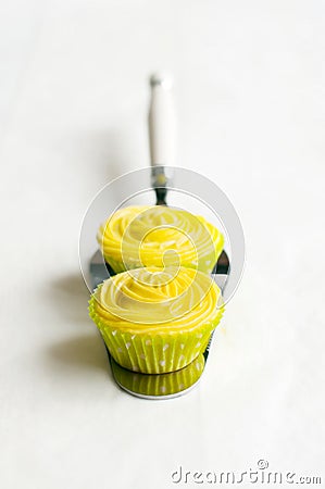 Yellow cupcakes on cake shovel, white background. Stock Photo