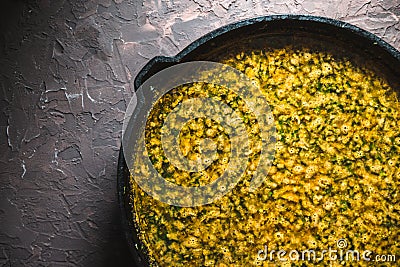 Yellow curry paste in a cast-iron frying pan closeup. Indian food Stock Photo