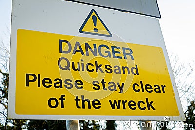 Yellow Danger Quicksand, please say clear of the wreck sign on a tree Stock Photo