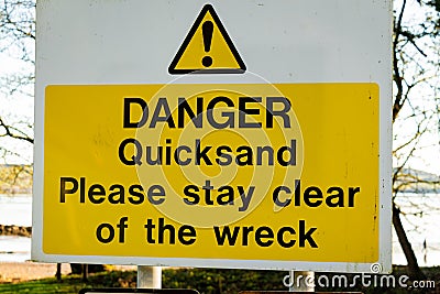 Yellow Danger Quicksand, please say clear of the wreck sign on a tree Stock Photo