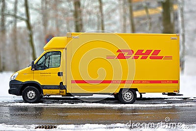 Yellow DHL international courier and parcel deliivery service truck in snow Editorial Stock Photo