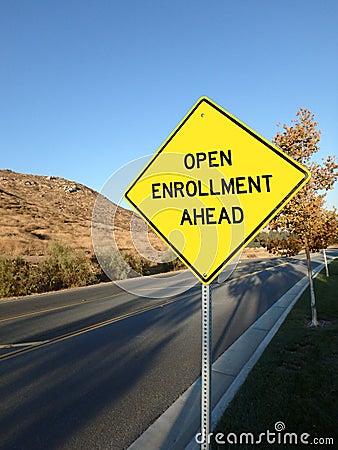 Yellow diamond road sign announcing open enrollment ahead Stock Photo