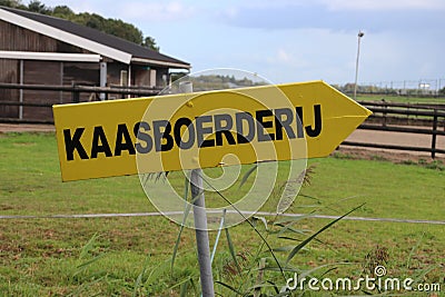 Yellow direction sign to a cheese farm in Dutch language Kaasboerderij in Nieuwerkerk aan den IJssel in the Netherlands Editorial Stock Photo