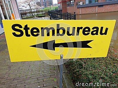 Yellow direction sign to polling station named stembureau in dutch for elections of the regional parlement in the Netherlands. Editorial Stock Photo