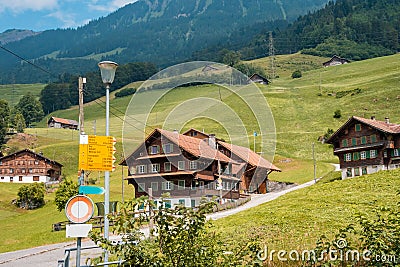 Yellow directional road signs. Wooden house in the background. Stock Photo