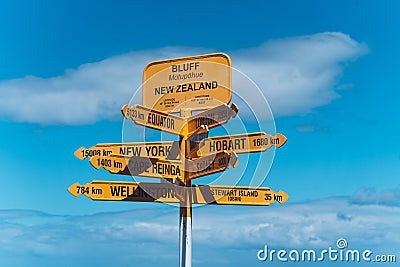 Yellow directional sign against a backdrop of a blue sky in New Zealand. Stock Photo